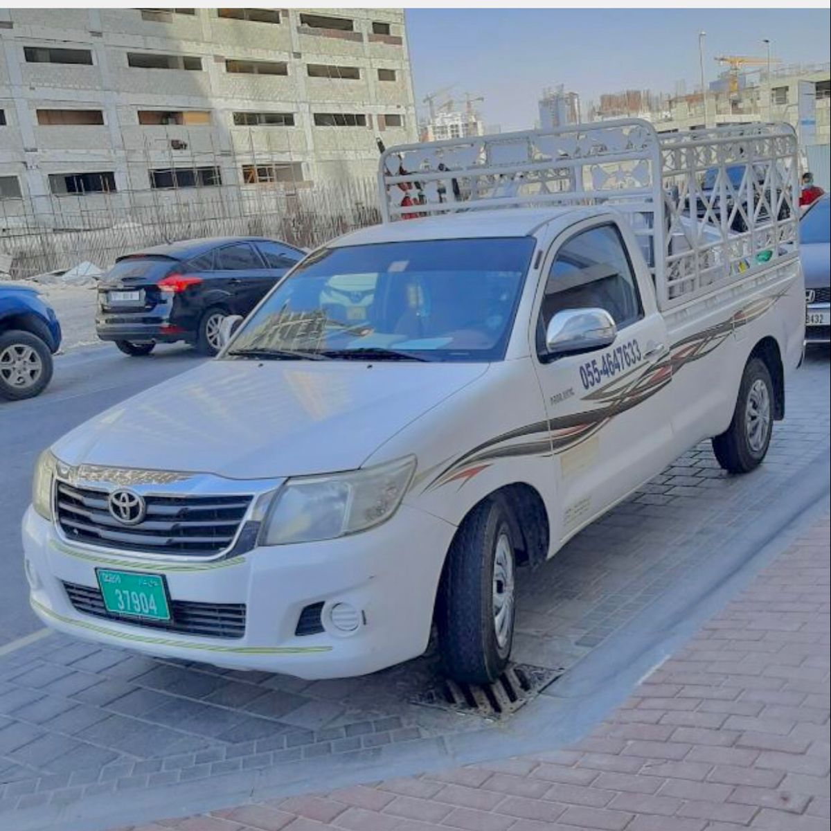 White Toyota one-ton pickup truck with cargo cage for furniture and business deliveries in Dubai